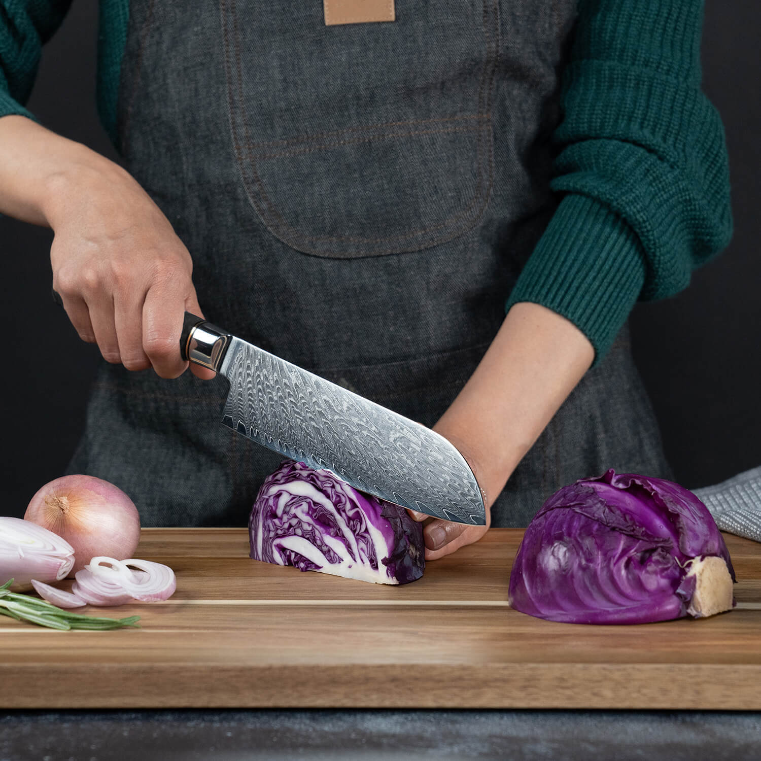 Person cutting purple cabbage on a wooden board with a chef's knife.