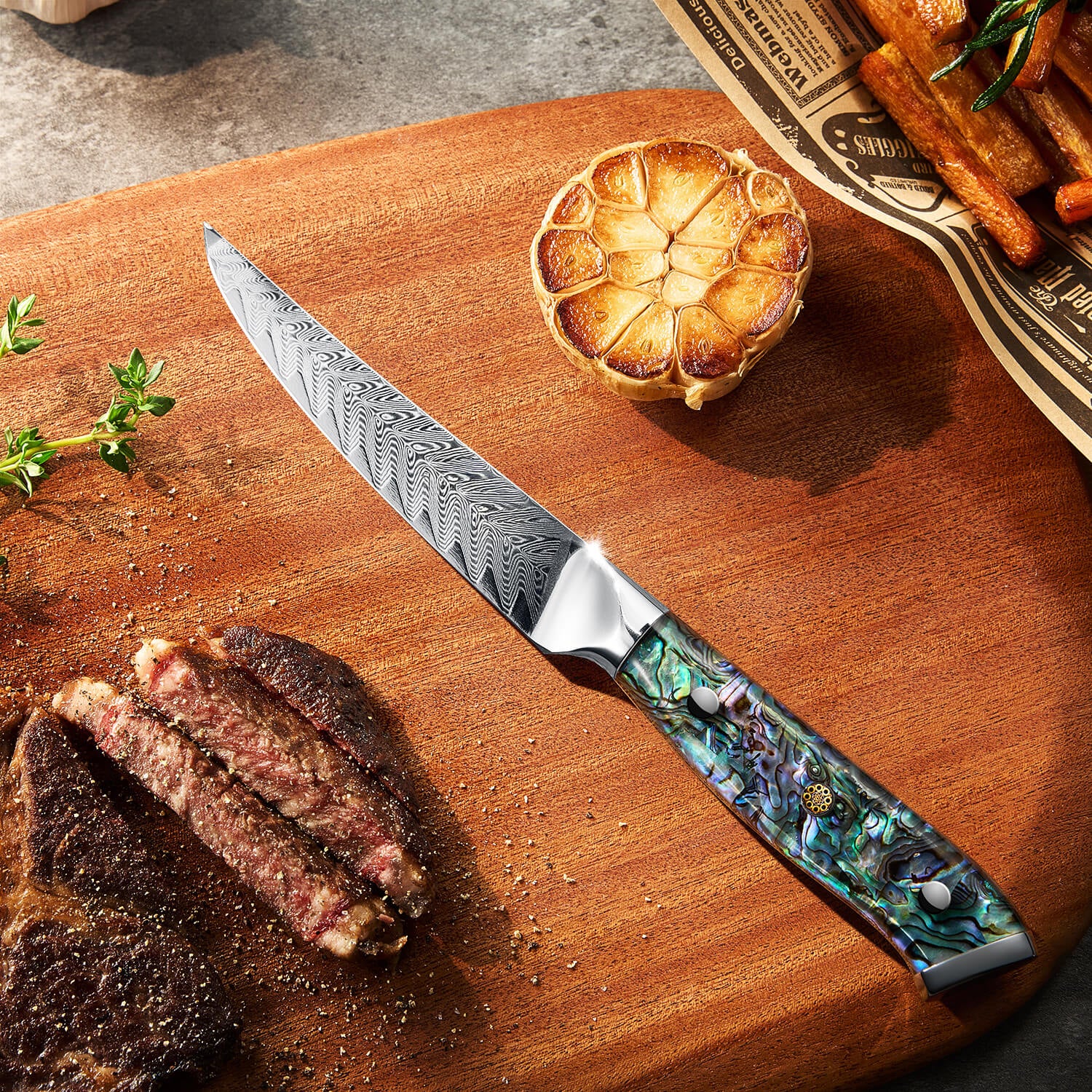 Senken Steak Knife on a wooden cutting board with cooked meat, garlic, and herbs.