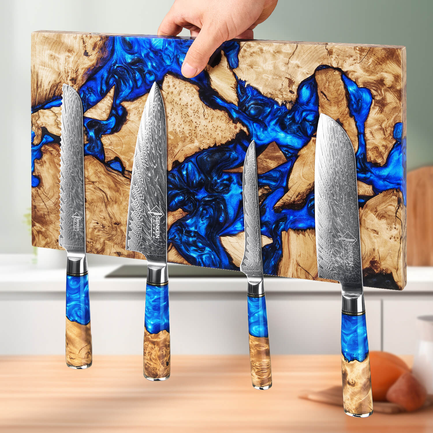 Set of four knives with blue resin handles on a wooden magnetic knife block.