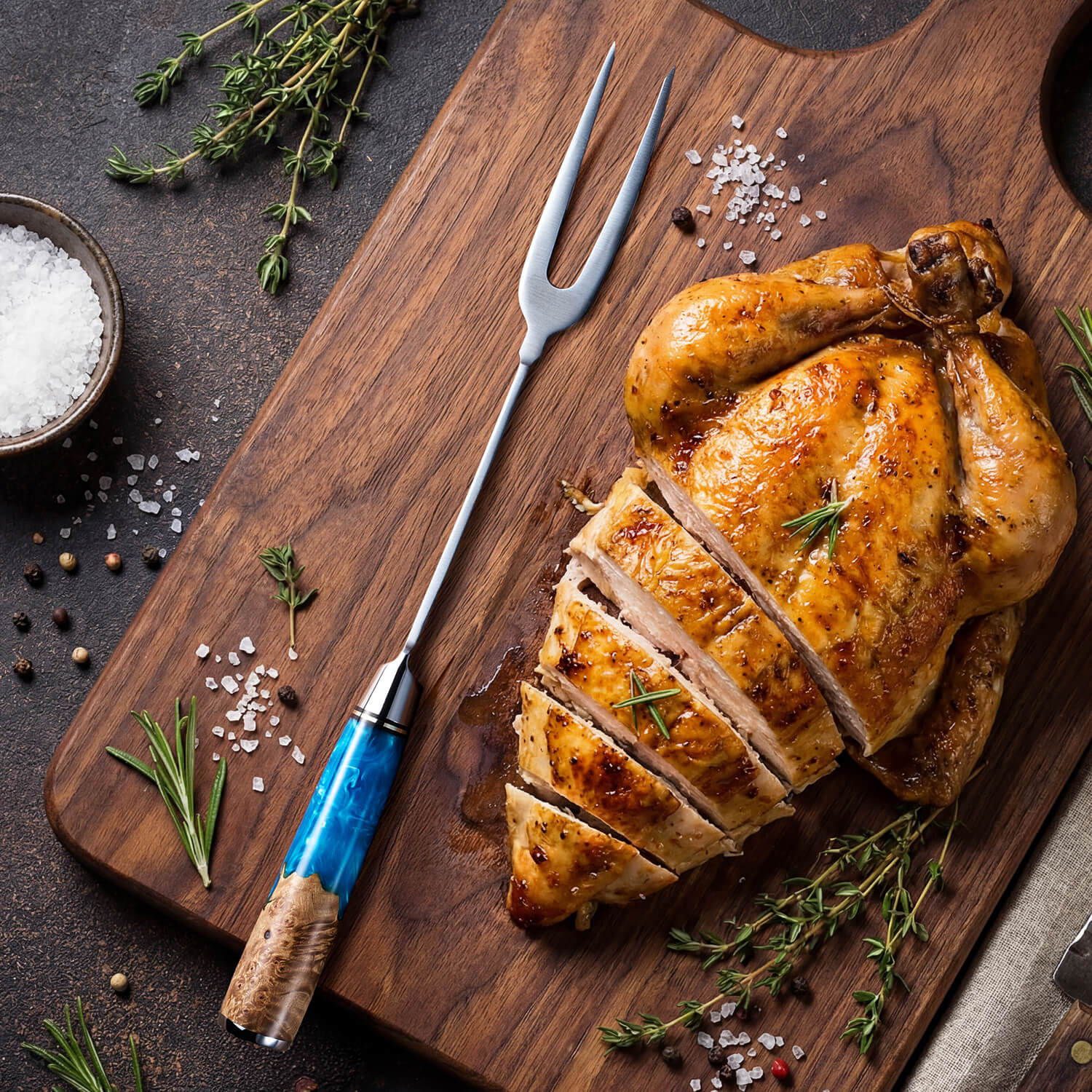 Roasted chicken on a wooden cutting board with herbs and spices