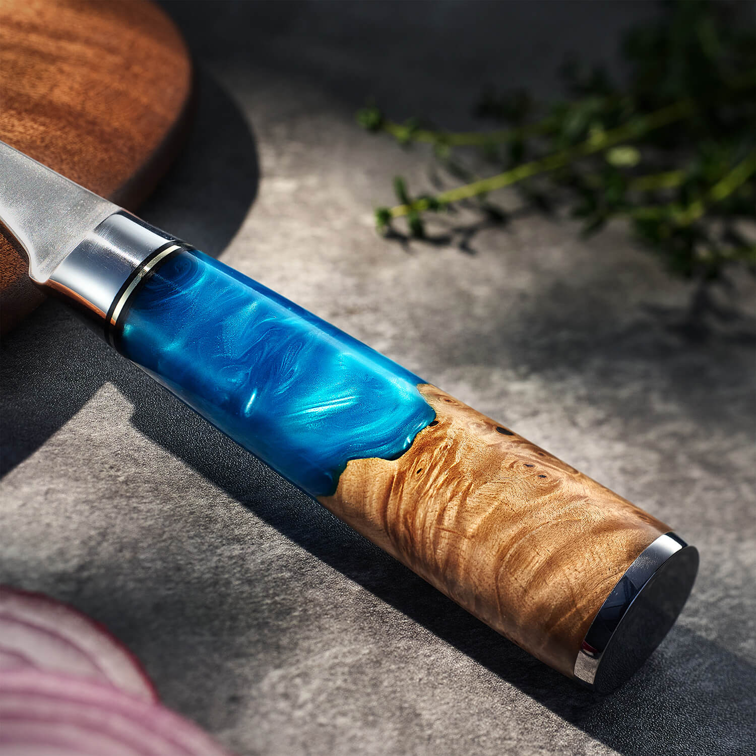 Knife with wooden handle and blue resin inlay on a textured surface